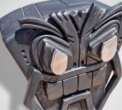 Metallic mask with a detailed design on a gray background